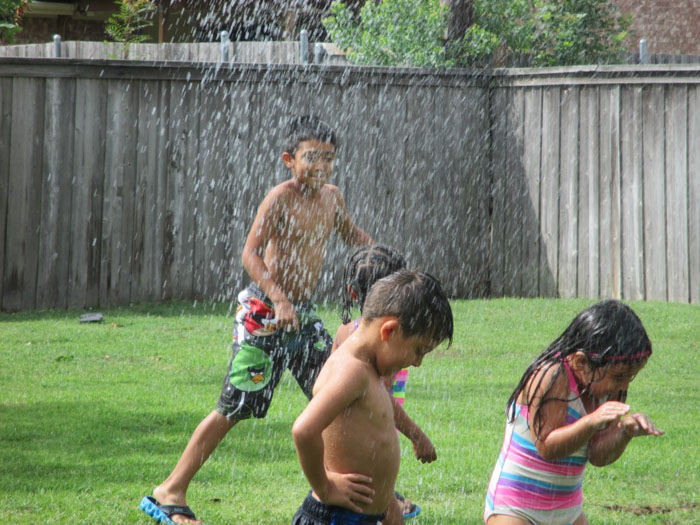 children playing and taking a bath outside